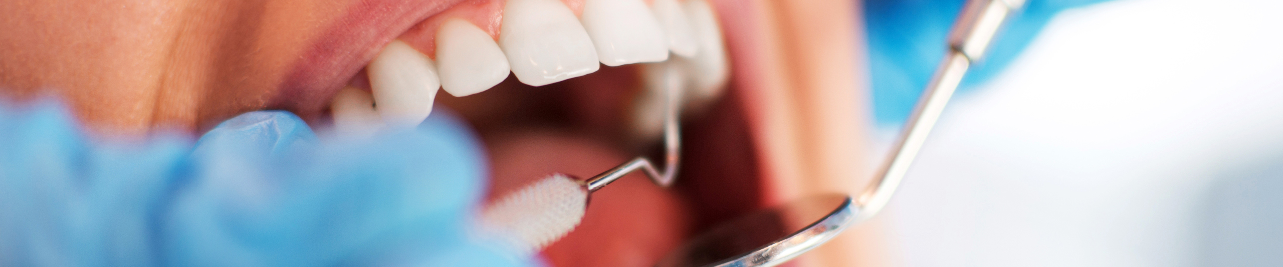 Tænder der er ved at blive undersøgt med tandlægeudstyr